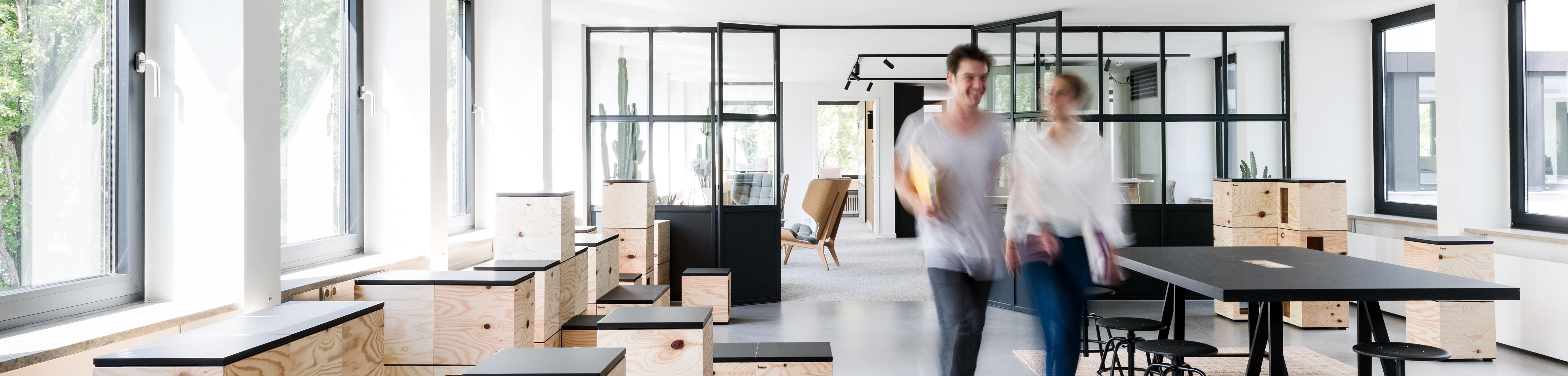 Zwei Menschen gehen durch einen Raum für kollaboratives Arbeiten